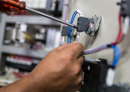 Electricians hands repair switches in electric control